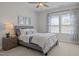 This bedroom features neutral walls, plush carpet, natural light, and a ceiling fan at 3215 Jones Lake Rd, Fuquay Varina, NC 27526