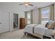 Bright bedroom with ensuite bathroom, dresser, ceiling fan, and large windows that let in lots of natural light at 3215 Jones Lake Rd, Fuquay Varina, NC 27526