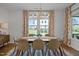 Bright dining room with natural light, chandelier, table with seating for six, and large windows at 3215 Jones Lake Rd, Fuquay Varina, NC 27526