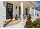Inviting front porch with a black door, decorative wreath, and seating area at 3215 Jones Lake Rd, Fuquay Varina, NC 27526