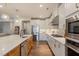 Stylish kitchen featuring a large island with seating, white cabinets, and stainless steel appliances at 3215 Jones Lake Rd, Fuquay Varina, NC 27526