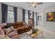 The living room has a large leather couch, a ceiling fan, and lots of natural light at 3215 Jones Lake Rd, Fuquay Varina, NC 27526