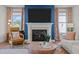 Cozy fireplace with a mantel, a blue accent wall, and chic furnishings in the living room at 3215 Jones Lake Rd, Fuquay Varina, NC 27526