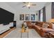 The living room has a large brown leather couch, movie posters, and a ceiling fan at 3215 Jones Lake Rd, Fuquay Varina, NC 27526