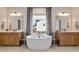 Spa-like main bathroom with a soaking tub, dual vanities, and elegant fixtures, perfect for relaxation at 3215 Jones Lake Rd, Fuquay Varina, NC 27526
