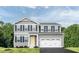 Charming two-story home featuring a two-car garage, yellow front door, and neatly manicured lawn with tasteful landscaping at 351 Tormore Dr, Sanford, NC 27330