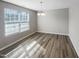 Bright dining room with luxury vinyl plank flooring, a modern chandelier, and a large window at 480 Stonewall Dr, Mebane, NC 27302