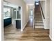 Hallway featuring luxury vinyl plank flooring, leading to a staircase and open-concept kitchen and living area at 480 Stonewall Dr, Mebane, NC 27302