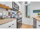 A modern kitchen featuring a black cooktop with stainless steel microwave and wood accents above the countertop at 521 N Mangum St # 12, Durham, NC 27701