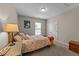 Cozy bedroom with warm neutral colors, a patterned comforter, and a quaint bedside table at 5213 Orabelle Ct, Raleigh, NC 27606