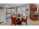 Bright dining area with a modern table set, natural light, and a view of the screened porch at 5213 Orabelle Ct, Raleigh, NC 27606