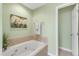 Bathroom featuring bathtub with tile surround and plant decor at 6013 Kohler Ln, Raleigh, NC 27616