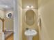 Cozy half-bathroom featuring a pedestal sink, decorative mirror, and neutral wall color at 6013 Kohler Ln, Raleigh, NC 27616