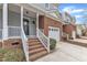 Brick townhome featuring a one-car garage, covered porch, and well-maintained front yard at 6013 Kohler Ln, Raleigh, NC 27616