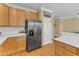 Kitchen view features stainless steel refrigerator, light wood cabinets, and white subway tile backsplash at 6013 Kohler Ln, Raleigh, NC 27616