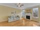 Cozy living room with hardwood floors, a fireplace, and natural light coming through the windows at 6013 Kohler Ln, Raleigh, NC 27616