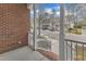 Relaxing view of the neighborhood street from the covered front porch with white railing and brick base at 6013 Kohler Ln, Raleigh, NC 27616