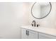 Modern powder room featuring black fixtures, white vanity, and a stylish round mirror at 604 S Chavis St, Franklinton, NC 27525