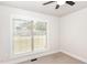 A sunlit bedroom with neutral carpeting and a large window with outdoor views at 604 S Chavis St, Franklinton, NC 27525