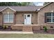 Charming brick home featuring a welcoming front porch with elegant white door and manicured landscaping at 604 S Chavis St, Franklinton, NC 27525