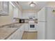Bright kitchen featuring white cabinetry, modern appliances, double stainless-steel sink and neutral countertops at 612 Pine Ridge Pl, Raleigh, NC 27609