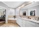Lovely bathroom featuring a corner tub, large vanity with double sinks, and a view into the walk-in closet at 7001 Millstone Ridge Ct, Raleigh, NC 27614