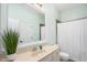 Well-lit bathroom featuring a wide mirror, neutral walls, and a white floral shower curtain at 7001 Millstone Ridge Ct, Raleigh, NC 27614