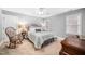 Cozy bedroom with a rocking chair, side tables with lamps, dresser and a window with blinds at 7001 Millstone Ridge Ct, Raleigh, NC 27614