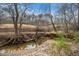 Scenic creek view featuring sandy banks, lush vegetation, and a classic wood fence backdrop at 7001 Millstone Ridge Ct, Raleigh, NC 27614