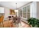Charming dining area with a wooden table, upholstered chairs, large windows, and hardwood floors at 7001 Millstone Ridge Ct, Raleigh, NC 27614