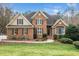 Charming brick home featuring a manicured lawn, mature trees, and a welcoming entrance at 7001 Millstone Ridge Ct, Raleigh, NC 27614