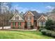 Charming brick home featuring a manicured lawn, mature trees, and a welcoming entrance at 7001 Millstone Ridge Ct, Raleigh, NC 27614