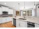 Bright kitchen with white cabinets, stainless appliances, granite countertops, and hardwood floors at 7001 Millstone Ridge Ct, Raleigh, NC 27614
