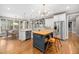 Spacious kitchen with white cabinets, stainless steel appliances, an island with seating, and hardwood floors at 7001 Millstone Ridge Ct, Raleigh, NC 27614