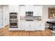 Kitchen featuring stainless steel appliances, including double oven and gas cooktop, with white cabinets at 7001 Millstone Ridge Ct, Raleigh, NC 27614