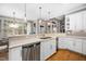 Open kitchen with white cabinets, stainless steel appliances, and a breakfast bar overlooking the dining area at 7001 Millstone Ridge Ct, Raleigh, NC 27614