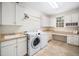 Spacious laundry room with white cabinets, folding counter, sink, and a modern washer and dryer at 7001 Millstone Ridge Ct, Raleigh, NC 27614