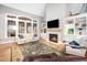 Bright and airy living room with a cozy fireplace, built-in shelving, and large windows at 7001 Millstone Ridge Ct, Raleigh, NC 27614
