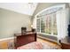 Well-lit office space with a large window, wooden desk, and neutral walls at 7001 Millstone Ridge Ct, Raleigh, NC 27614