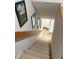 Carpeted stairway leads to a bright lower level with decorative wall art and a wooden handrail at 704 Martin Luther King Jr Blvd # D12, Chapel Hill, NC 27514