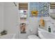 Bright bathroom with white tiles, patterned wallpaper, and a vintage-style sink and toilet at 712 Tarleton Ave, Burlington, NC 27215