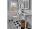 Classic bathroom featuring a single vanity sink, checkered floors, white subway tile walls, toilet and white shuttered window at 712 Tarleton Ave, Burlington, NC 27215