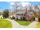 Expansive brick home with stately columns, well-manicured landscaping, a circular driveway, and mature trees at 712 Tarleton Ave, Burlington, NC 27215