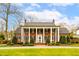 Stately brick home with white columns and manicured lawn under a blue sky at 712 Tarleton Ave, Burlington, NC 27215