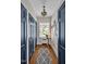 Hallway with hardwood floors, decorative rug, stained glass window, and blue doors at 712 Tarleton Ave, Burlington, NC 27215