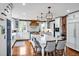 Spacious kitchen boasts white cabinetry, hardwood floors, a large island, and a brick accent wall at 712 Tarleton Ave, Burlington, NC 27215