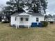 Front exterior featuring a covered porch and blue trashcans at 804 S Sampson Ave, Dunn, NC 28334