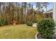 Large, grassy backyard with play set, shed and fire pit area surrounded by trees at 8816 Knights Union Way, Wake Forest, NC 27587