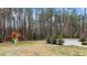 Large backyard with play set, shed, mature trees, and a fire pit at 8816 Knights Union Way, Wake Forest, NC 27587