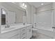 Bathroom features a double sink vanity, tiled floor and a shower/tub with white tile surround at 8816 Knights Union Way, Wake Forest, NC 27587